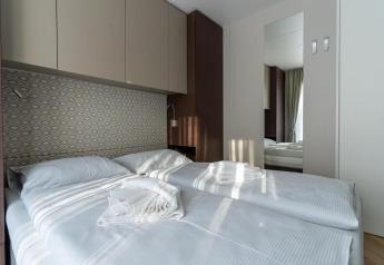 Moderne slaapkamer in Wulfenia bij Pressegger See, Oostenrijk, met twee bedden en lichte inrichting.