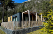 Moderne Wulfenia lodge aan Pressegger See in Oostenrijk, omringd door bergen en groene natuur.