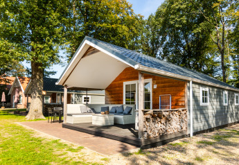 Outdoor view of Forest Lodge at Holiday park De Witte Berg in the Netherlands, surrounded by green trees.