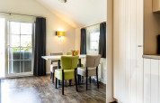 Eethoek in Forest Lodge op Holiday park De Witte Berg, Nederland, met veel lichtinval en eigentijdse stoelen.