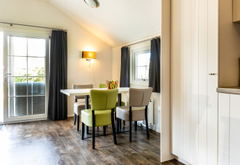 Eethoek in Forest Lodge op Holiday park De Witte Berg, Nederland, met veel lichtinval en eigentijdse stoelen.