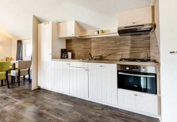 Moderne køkkenområde i Forest Lodge på ferieparken De Witte Berg i Holland med spiseplads synlig.