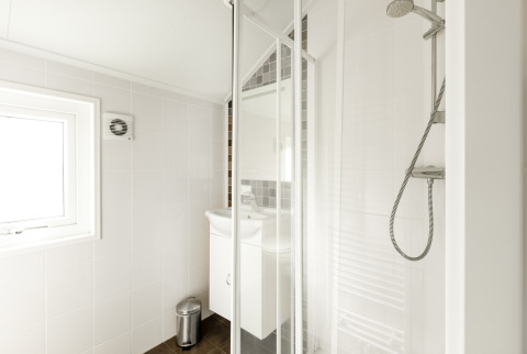 Modernes Badezimmer in der Forest Lodge im Holiday Park De Witte Berg, Niederlande, mit Dusche und Waschbecken.