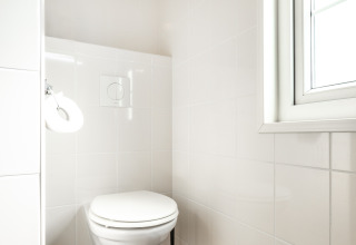 Bagno moderno e luminoso con WC sospeso nella Forest Lodge, Holiday park De Witte Berg, Paesi Bassi.