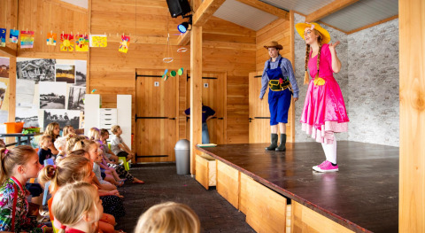 Kinderen kijken naar een toneelstuk in de Forest Lodge op vakantiepark De Witte Berg, Nederland.