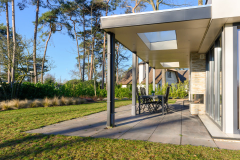 Moderne feriebolig med overdækket terrasse, glaslofter og have i ferieparken Ackersate, Holland.