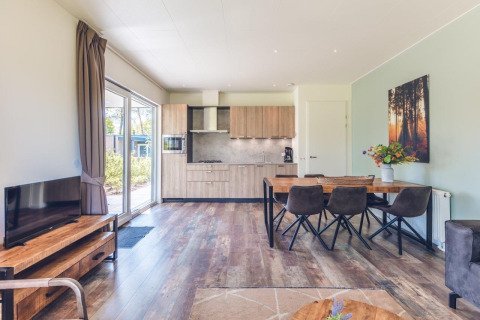 Sala y cocina luminosas en una villa vacacional moderna con sauna en Holiday park Ackersate, Países Bajos.