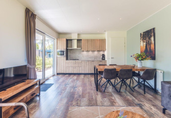 Sala y cocina luminosas en una villa vacacional moderna con sauna en Holiday park Ackersate, Países Bajos.
