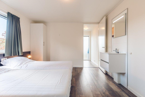 Habitación luminosa con dos camas individuales, armario y lavabo en Vacation villa + sauna, Ackersate.