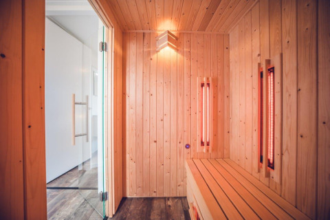 Vista interior de una moderna sauna con paneles de madera en la villa del Holiday park Ackersate, Países Bajos.