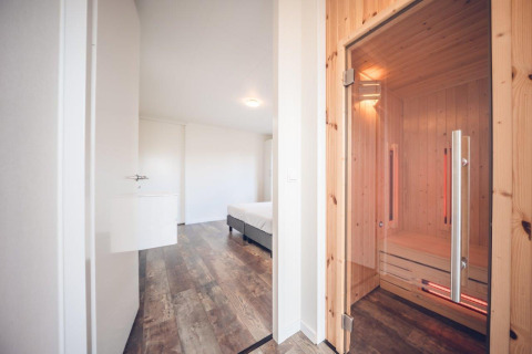 Villa vacacional moderna con sauna y suelo de madera en Holiday park Ackersate, Países Bajos, vista al dormitorio.