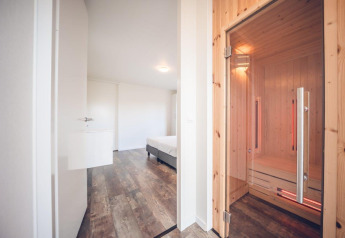 Villa vacacional moderna con sauna y suelo de madera en Holiday park Ackersate, Países Bajos, vista al dormitorio.