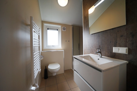 Bagno moderno con lavabo bianco, WC e grande specchio al Kids cottage di Kaatsheuvel, Paesi Bassi.