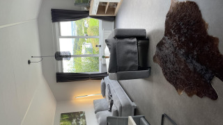 Moderne leefruimte in Chalet Brilon, Camping & Ferienpark Brilon, Duitsland, met groot raam en natuurzicht.