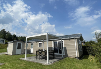 Vista exterior del Chalet Brilon en Camping & Ferienpark Brilon, Alemania, con terraza y muebles de jardín.