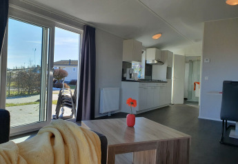 Sala y cocina luminosas en el Chalet Brilon, Camping & Ferienpark Brilon, Alemania, con vista al jardín.