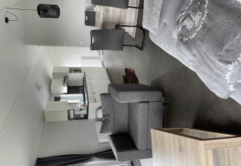 Vista interior del Chalet Brilon en Camping & Ferienpark Brilon, Alemania, con muebles y cocina modernos.