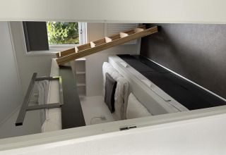 Habitación moderna con literas y escalera inclinada en Chalet Brilon, Camping & Ferienpark Brilon, Alemania.