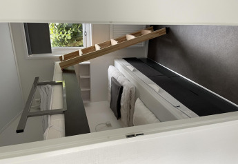 Habitación moderna con literas y escalera inclinada en Chalet Brilon, Camping & Ferienpark Brilon, Alemania.