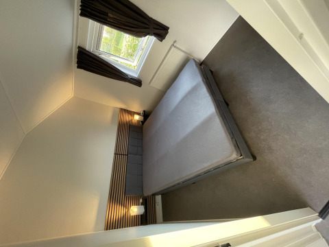 Dormitorio moderno en Chalet Brilon en Camping & Ferienpark Brilon en Alemania, con cama doble y ventana.