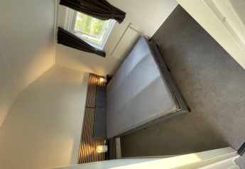 Dormitorio moderno en Chalet Brilon en Camping & Ferienpark Brilon en Alemania, con cama doble y ventana.