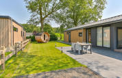 Vista exterior de una cabaña de lujo con sauna en Drentse Weelde, Países Bajos, con terraza y jardín.