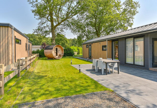 Vista exterior de una cabaña de lujo con sauna en Drentse Weelde, Países Bajos, con terraza y jardín.