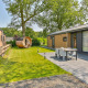 Vista esterna di una luxury lodge con sauna a Drentse Weelde, Paesi Bassi, con terrazza e giardino verde.