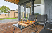 Terrazza esterna in un lodge di lusso a Drentse Weelde, Paesi Bassi, con vino, snack e sedute moderne.