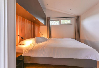 Dormitorio en la Luxury lodge + sauna en Drentse Weelde, Países Bajos, con cama grande y decoración moderna.