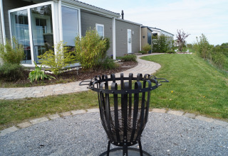 Chalet moderno chiamato Chalet Marron al Camping & Ferienpark Brilon, Germania, con giardino curato davanti.