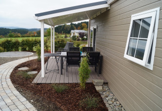Überdachte Terrasse am Chalet Marron im Camping & Ferienpark Brilon mit Blick auf Natur und Wiesen in Deutschland.