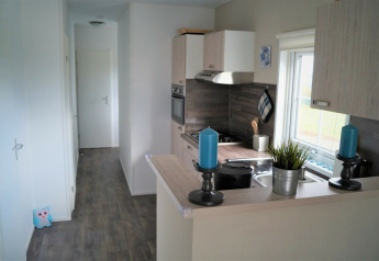 Cocina luminosa y moderna en Chalet Marron de Camping & Ferienpark Brilon, Alemania, con velas azules.