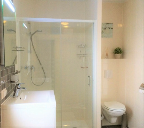 Moderne badkamer met douche, toilet en lavabo in Chalet Marron op Camping & Ferienpark Brilon, Duitsland.