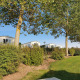 Drie luxueuze chalets tussen groen bij Camping & Ferienpark Brilon onder een blauwe lucht met zon.