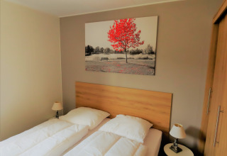 Dormitorio en Chalet Brilon con dos camas individuales, arte moderno en la pared y luz cálida en Alemania.