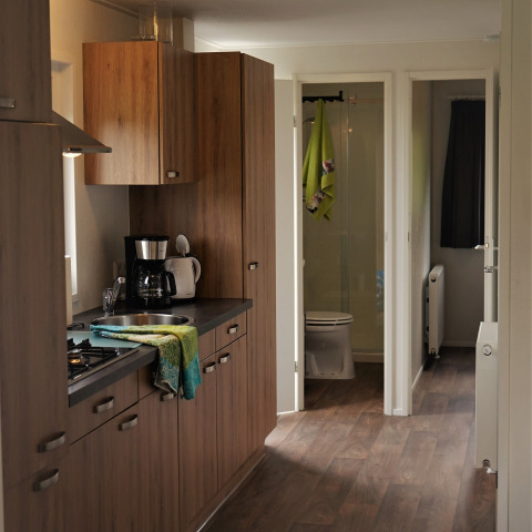 Cocina moderna de madera en Chalet Brilon, Camping & Ferienpark Brilon, Alemania, con vista al baño.