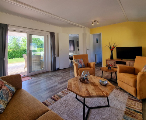 Luminoso soggiorno nel Chalet Limonet, Camping & Ferienpark Brilon, Germania, con vista su terrazza e giardino.