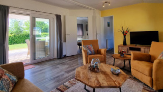 Salón luminoso en Chalet Limonet, Camping & Ferienpark Brilon, Alemania, con vistas a terraza y jardín.