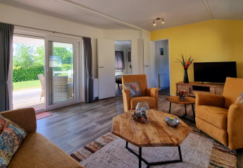 Salón luminoso en Chalet Limonet, Camping & Ferienpark Brilon, Alemania, con vistas a terraza y jardín.