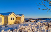 Casa mobile gialla Chalet Limonet innevata al Camping & Ferienpark Brilon, Germania, sotto cielo azzurro.