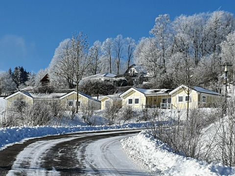 Vista invernal de casas móviles cubiertas de nieve en Chalet Limonet, Camping & Ferienpark Brilon, Alemania.