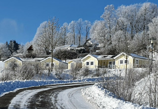 Vista invernal de casas móviles cubiertas de nieve en Chalet Limonet, Camping & Ferienpark Brilon, Alemania.