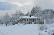 Escena invernal de la cabaña Calcelux cubierta de nieve en Camping & Ferienpark Brilon, Alemania.