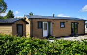 Vista exterior del Chalet Alme, una moderna cabaña de madera en Camping & Ferienpark Brilon, Alemania, día soleado