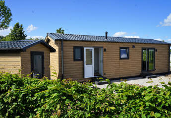 Vista esterna di Chalet Alme, una moderna baita in legno al Camping & Ferienpark Brilon in Germania, giornata soleggiata