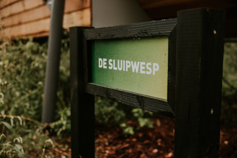 Letrero con el texto 'De Sluipwesp' en Skycabin, una casa natural en Camping Si-Es-An en los Países Bajos.