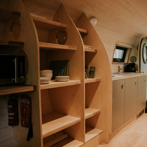 Estanterías de madera y cocina moderna en Skycabin, una casa natural en Camping Si-Es-An, Países Bajos.