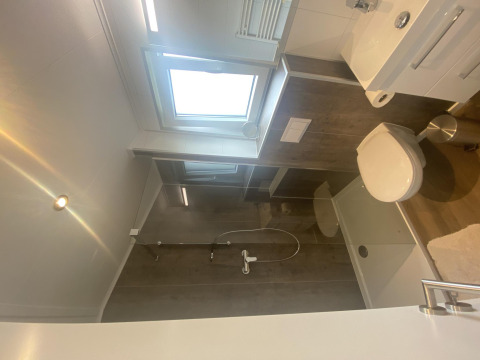 Baño moderno con ducha, inodoro, lavabo y ventana en Chalet Waldfee, Camping & Ferienpark Brilon, Alemania.