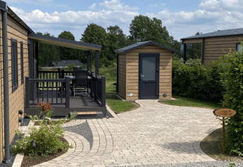 Vista exterior del Chalet Waldfee en Camping & Ferienpark Brilon, Alemania, con terraza y sendero.